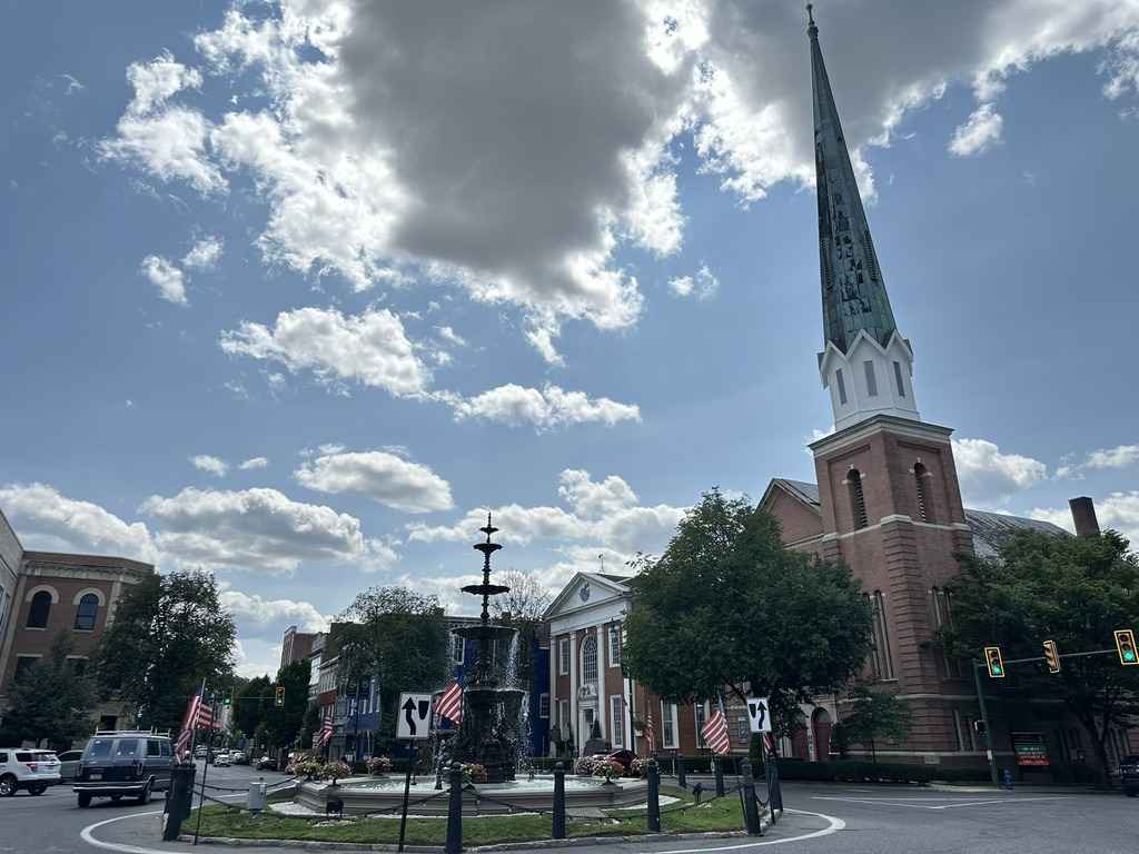 Chambersburg town square with a tall church steeple and vibrant flags in Franklin County.