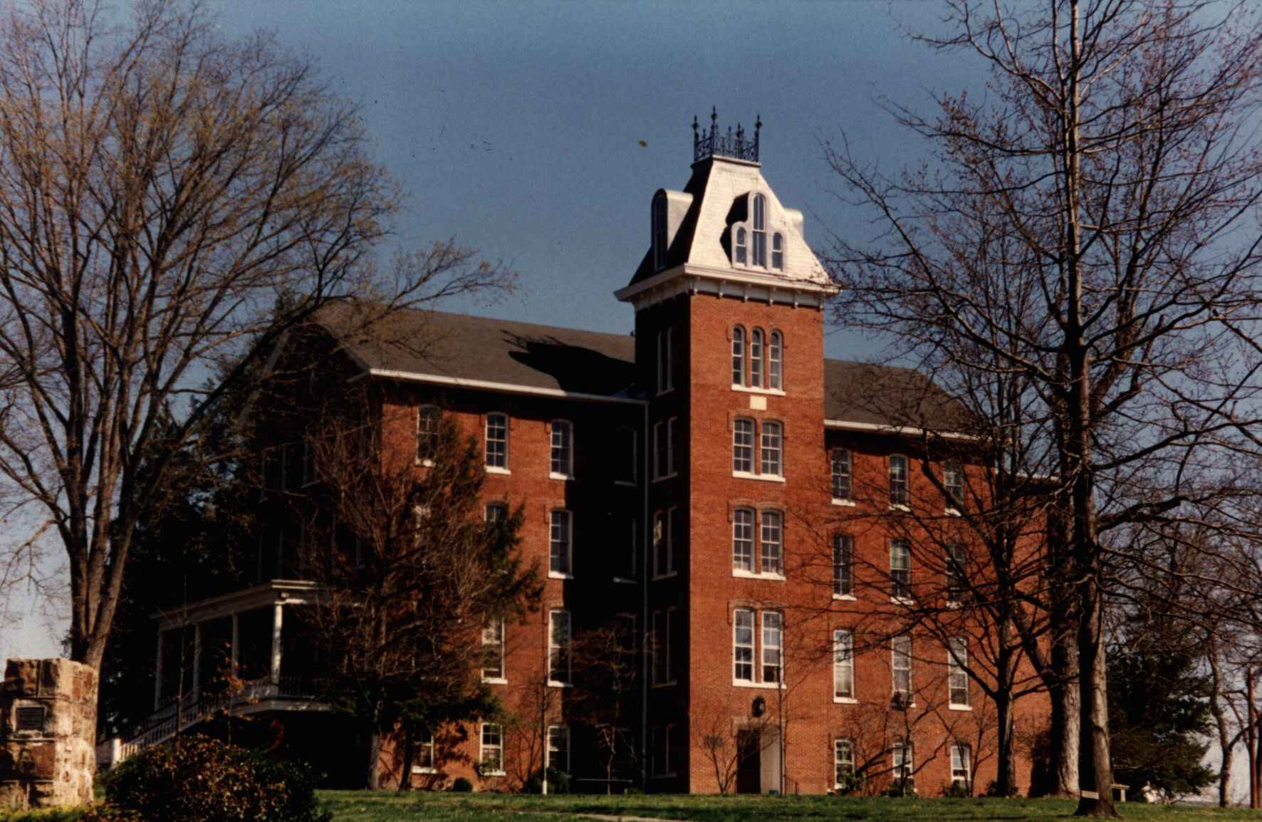 A color photograph of Founders Hall at Juniata College in Huntingdon County, Pennsylvania, showing its red-brick facade, white trim, and an ornate cupola, framed by leafless trees.