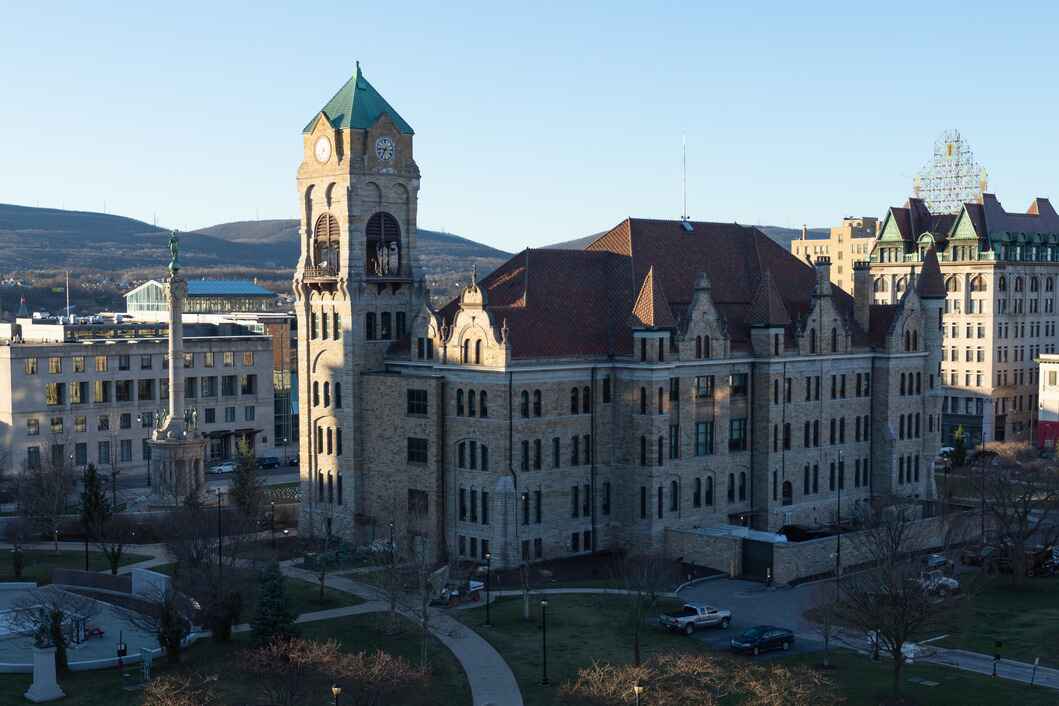The historic Lackawanna County Courthouse in Scranton, Pennsylvania, features a grand clock tower and stone architecture against a blue sky.