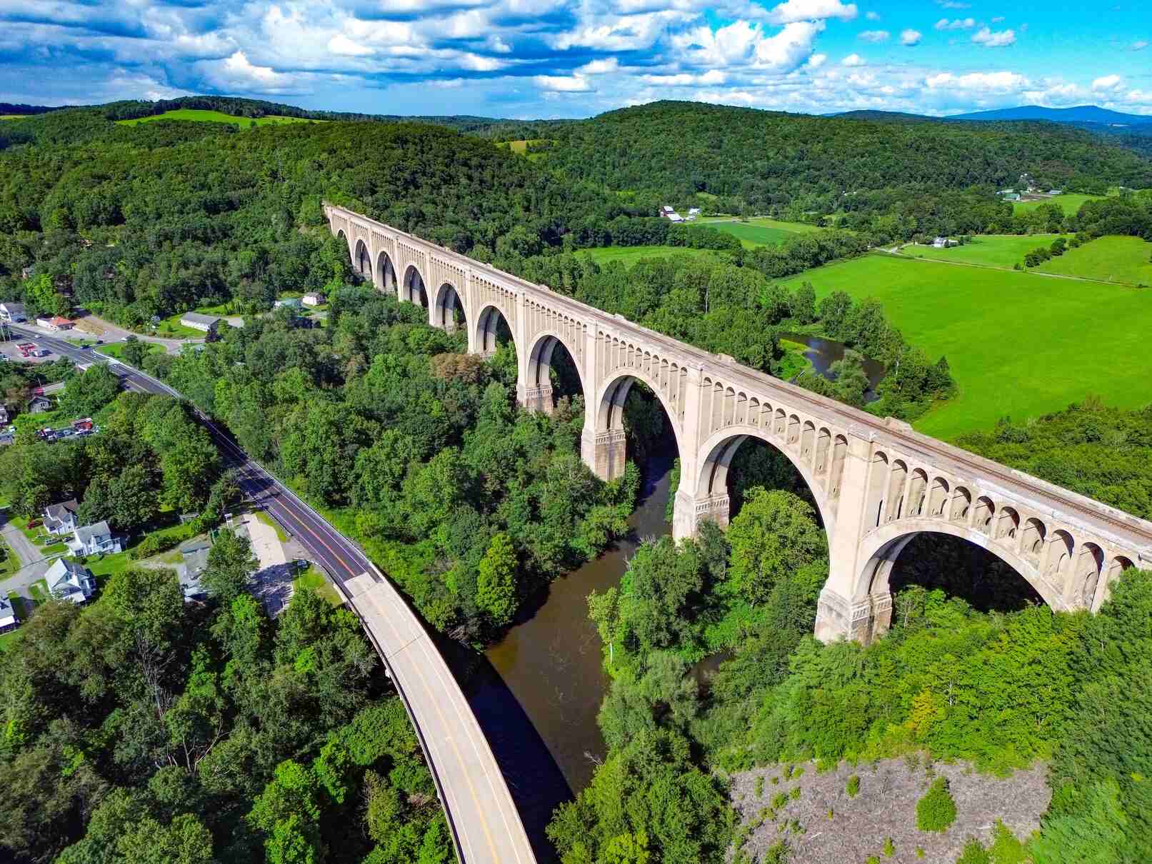 Aerial view of the Tunkhannock Creek Viaduct crossing lush green fields and forest in Wyoming County, PA.