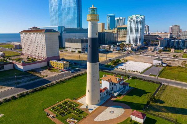 The historic Absecon Lighthouse stands tall against the Atlantic City skyline, with green lawns and a well-kept garden in South Jersey, New Jersey.