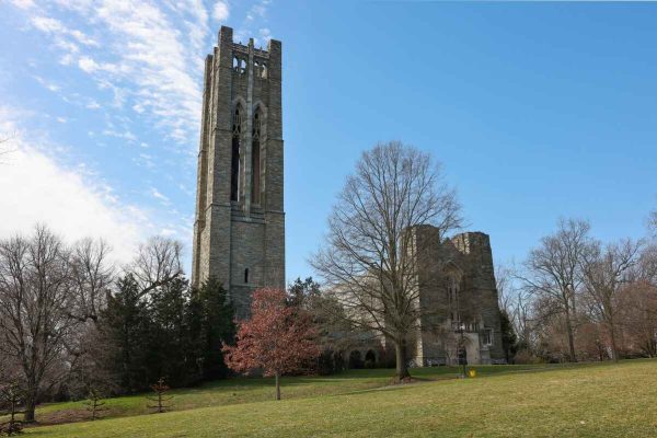 The tall stone tower of Clothier Memorial Hall stands against a bright blue sky near Swarthmore College in Delaware County.