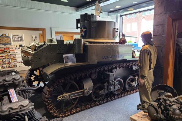 A World War II Stuart tank on display at the Stuart Tank Museum in Columbia County, featuring a lifelike mannequin dressed in military attire, surrounded by historical artifacts.