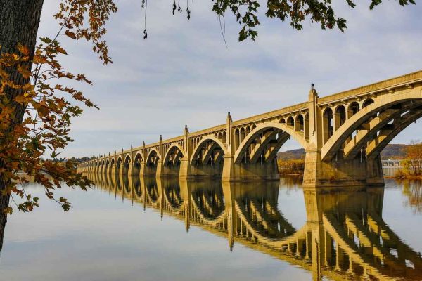 The historic Susquehanna River Bridge in Lancaster County, with its arched concrete supports reflecting in the calm water.